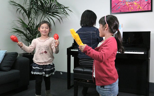 two children playing musical games with the piano